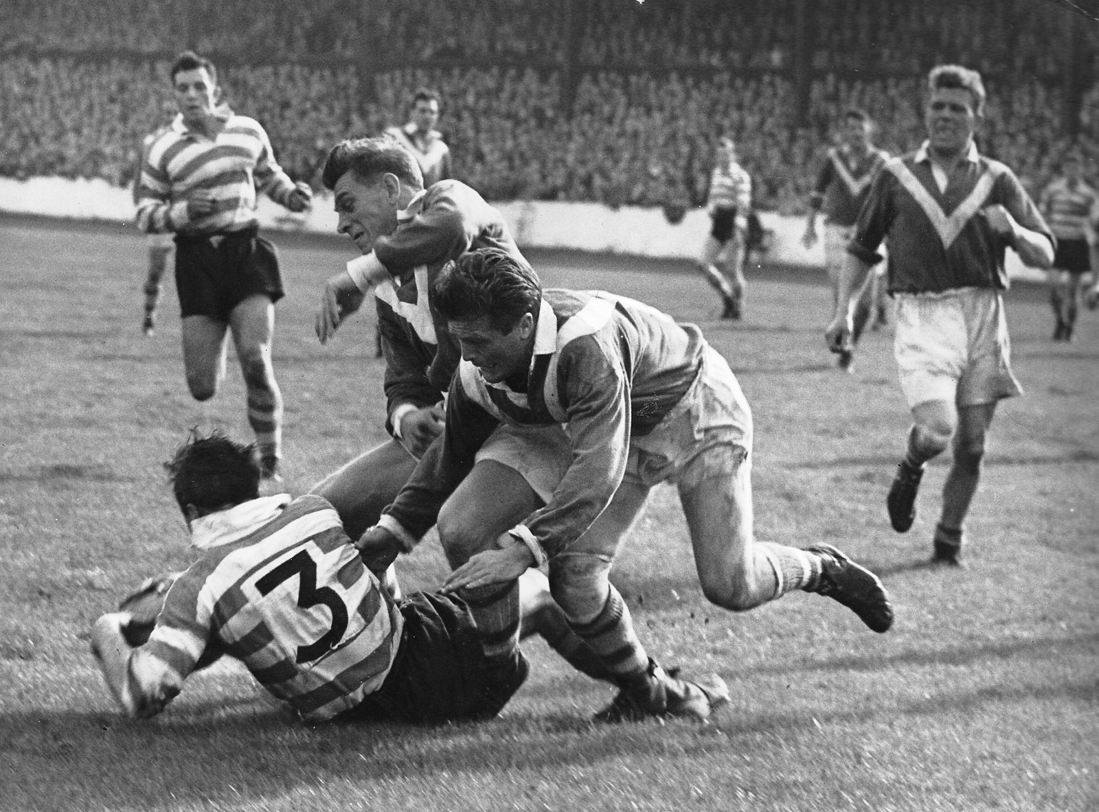 Dennis Ayres is pulled down by Len McIntrye. - Sep 22nd 1956.