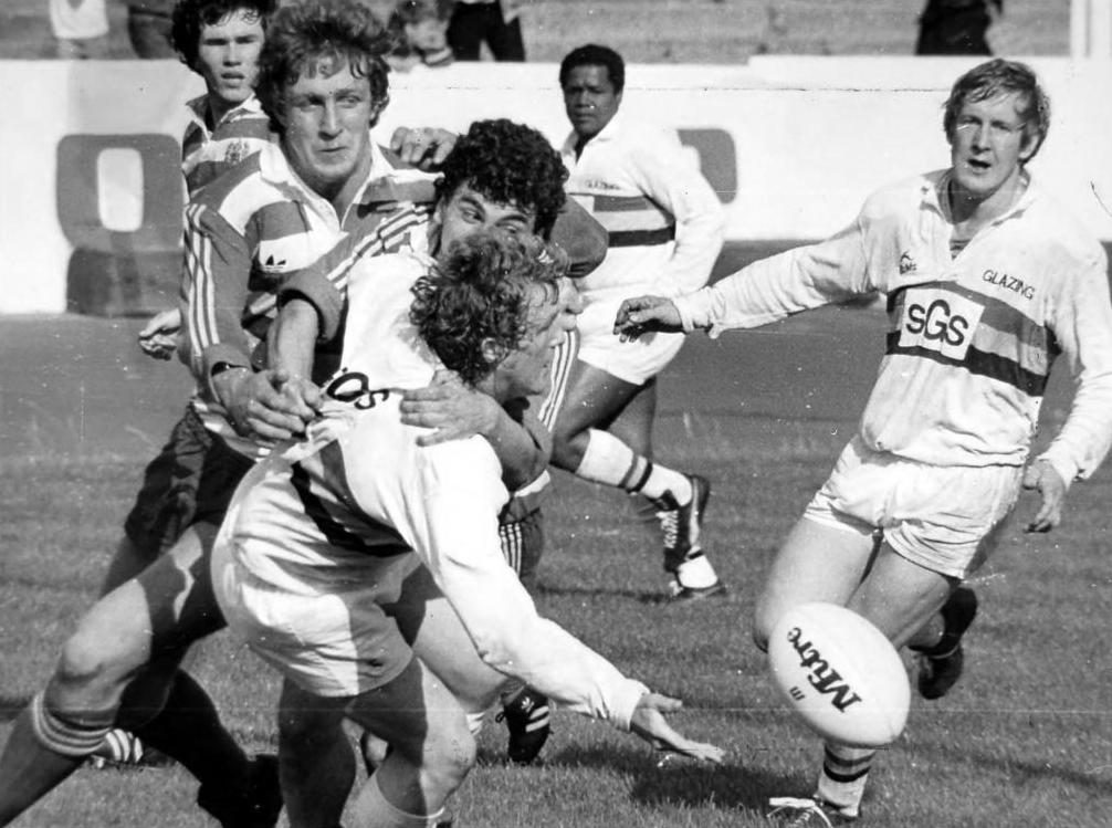 Alan Redfearn (Bradford) gets out a pass in a tackle by Ray Ashton and Mick Parrish - Aug 29th 1982.