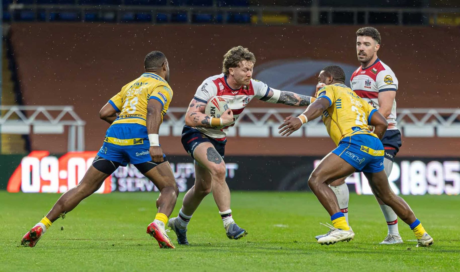 Tom Nisbet with ball in hand, watched on by Ewan Moore.