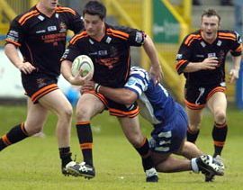 Oldham's Matt Bottom (Ieft) and Paul Ashton (right) move in as Wayne Corcoran looks to make ground towards the Halifax line June 4th 2006.