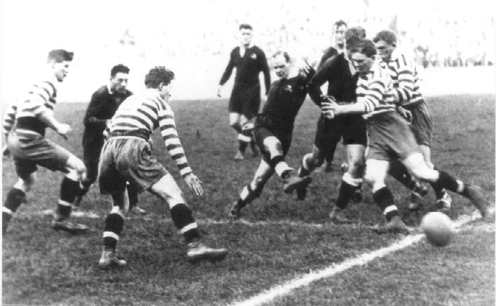 Kiwi half-back Hector Brisbane gets a kick away as the Oldham pack closes in - Oct 23rd 1926.