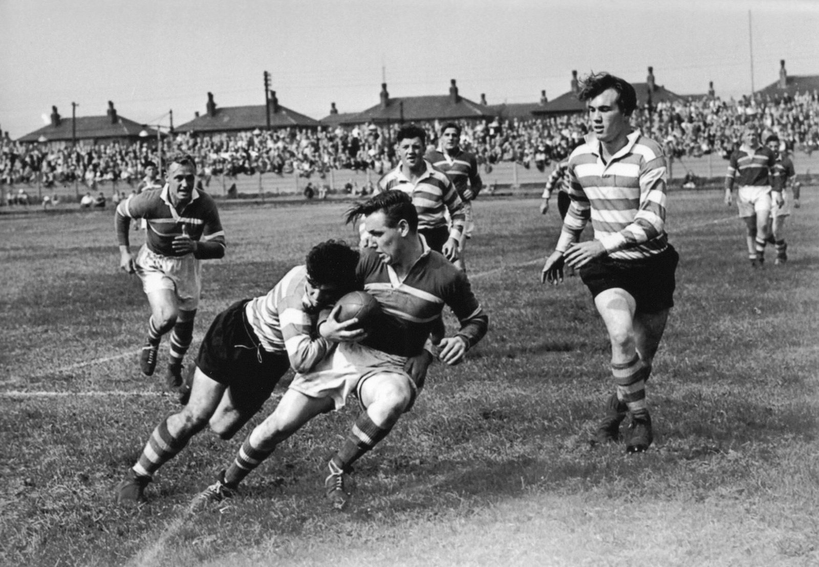 Alan Davies tackles Alan Taylor with Terry O’Grady and Harry Ogden in the background, while Walter Jones races in to support his stand-off half - Aug 13th 1955.