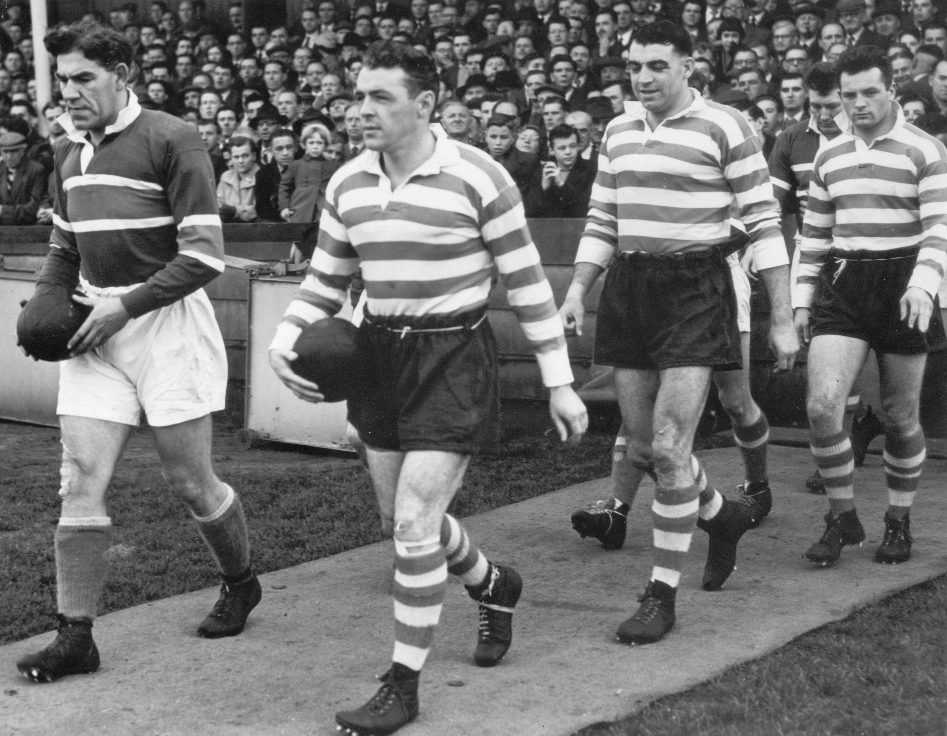 The crowd waits in anticipation as Bernard Ganley calmly leads out the team followed by Dick Cracknell and Dennis Ayres before the start of the match at Rochdale - Oct 12th 1957.