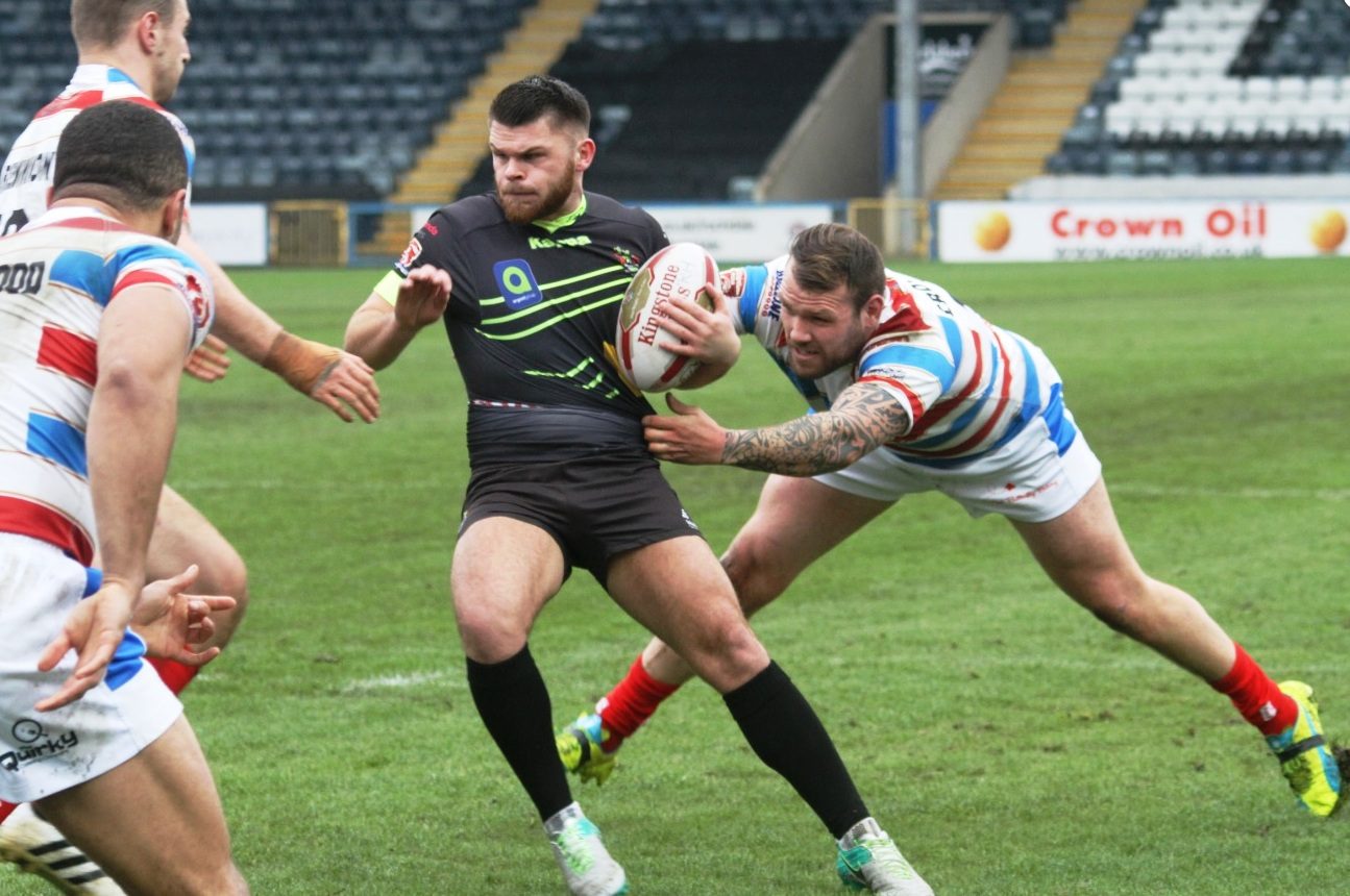 Josh Crowley grabs the shirt of David Hewitt. Rochdale v Oldham - March 12th 2017.
