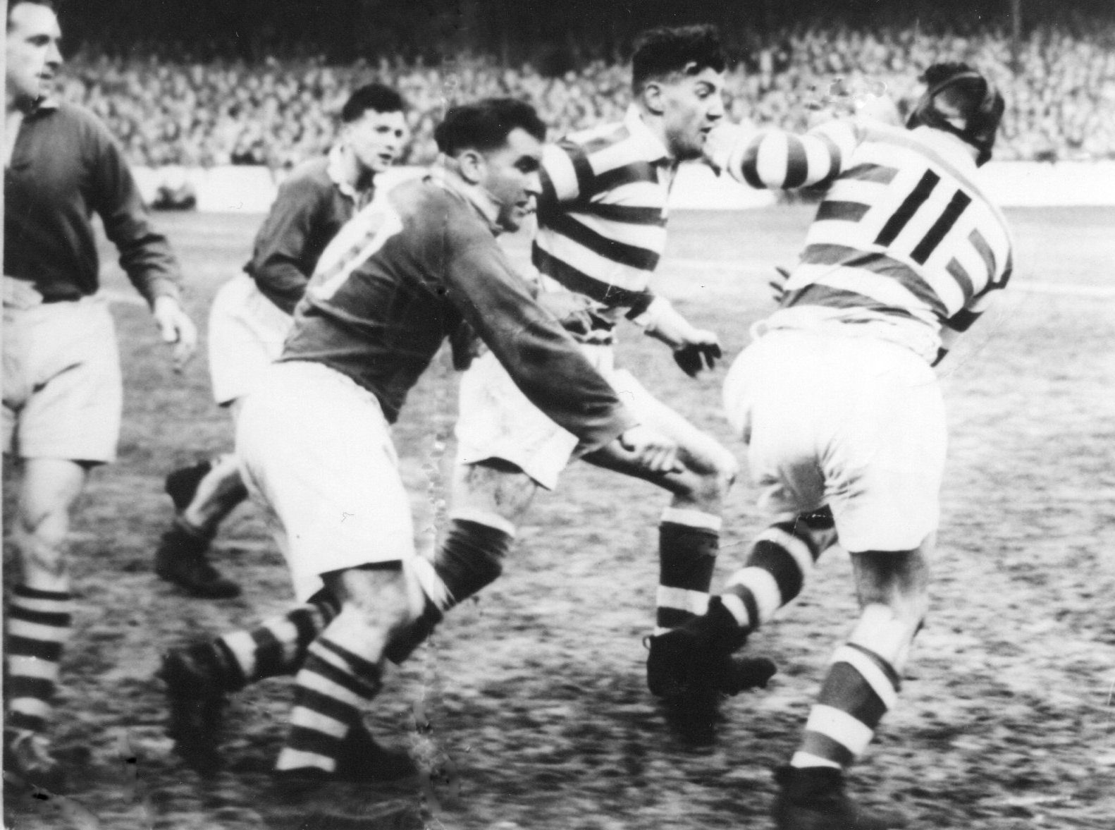Harry Ogden copes with the attentions of the Salford prop, Eynon Hawkins, as he slips the ball to Albert Fearnley who breaks clear - April 7th 1950.