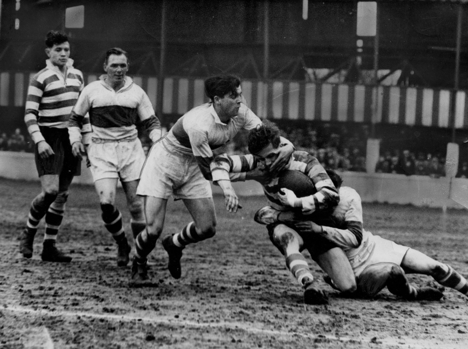 Oldham winger Lionel Emmitt is tackled by Jimmy Honey and Peter Metcalfe of St. Helens, while Alan Davies and George Langfield keep a close watch - April 18th 1953.