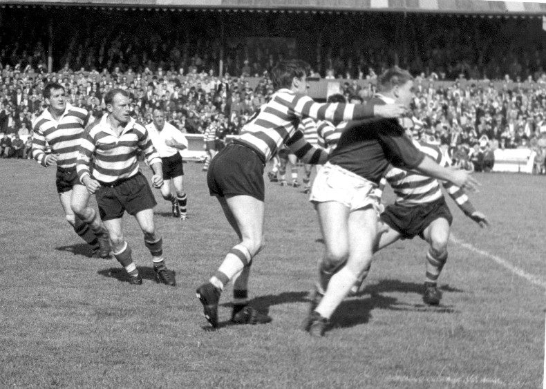 John Donovan makes a tackle watched by Harry Major, Jack Pycroft and Vince Nestor (hidden) - Aug 29th 1964.