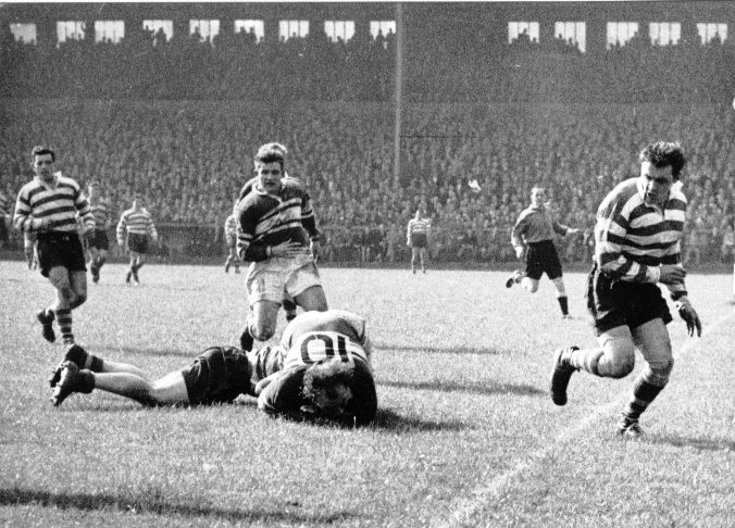 Brian McTigue is brought down by an Oldham player with Bernard Ganley and Alan Davies in attendance - Sep 1st 1956.