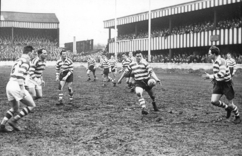 Derek Turner puts in a kick watched by his team-mates as the Wigan defence closes in - March 30th 1957.