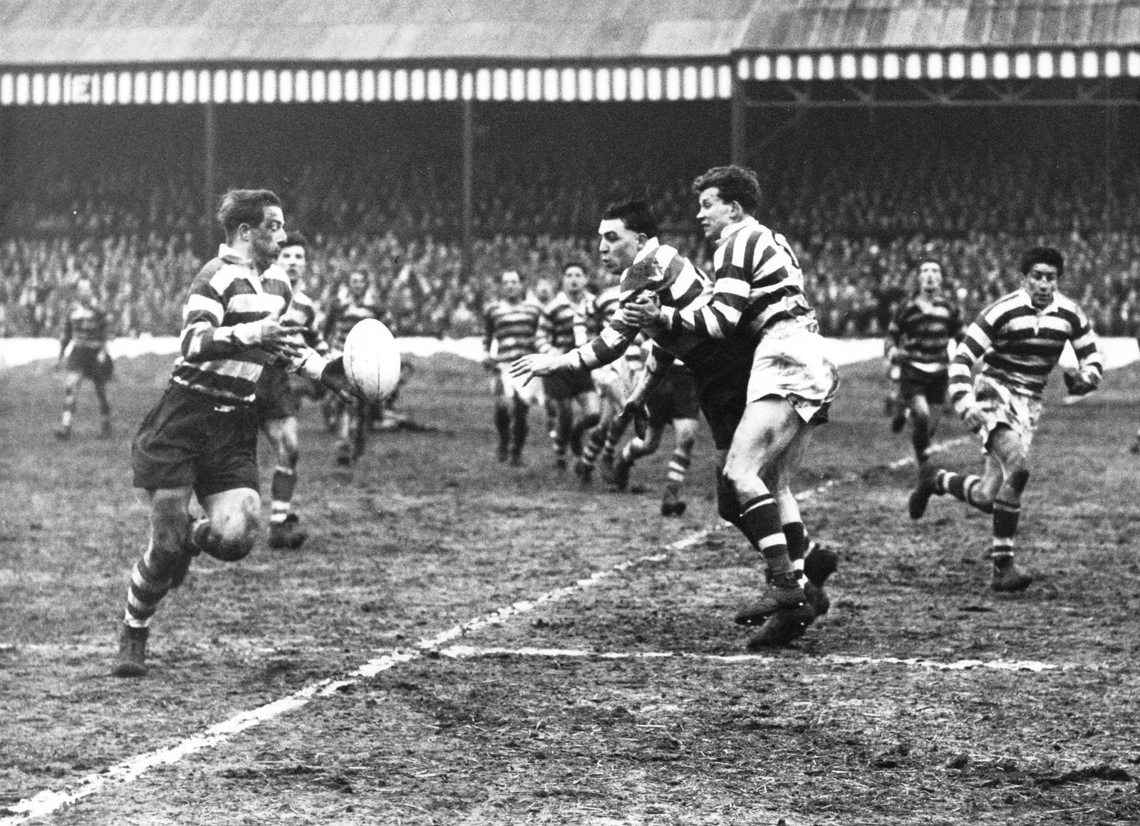 Dick Cracknell passes to Vince Nestor in Mick Sullivan's tackle - April 5th 1958.