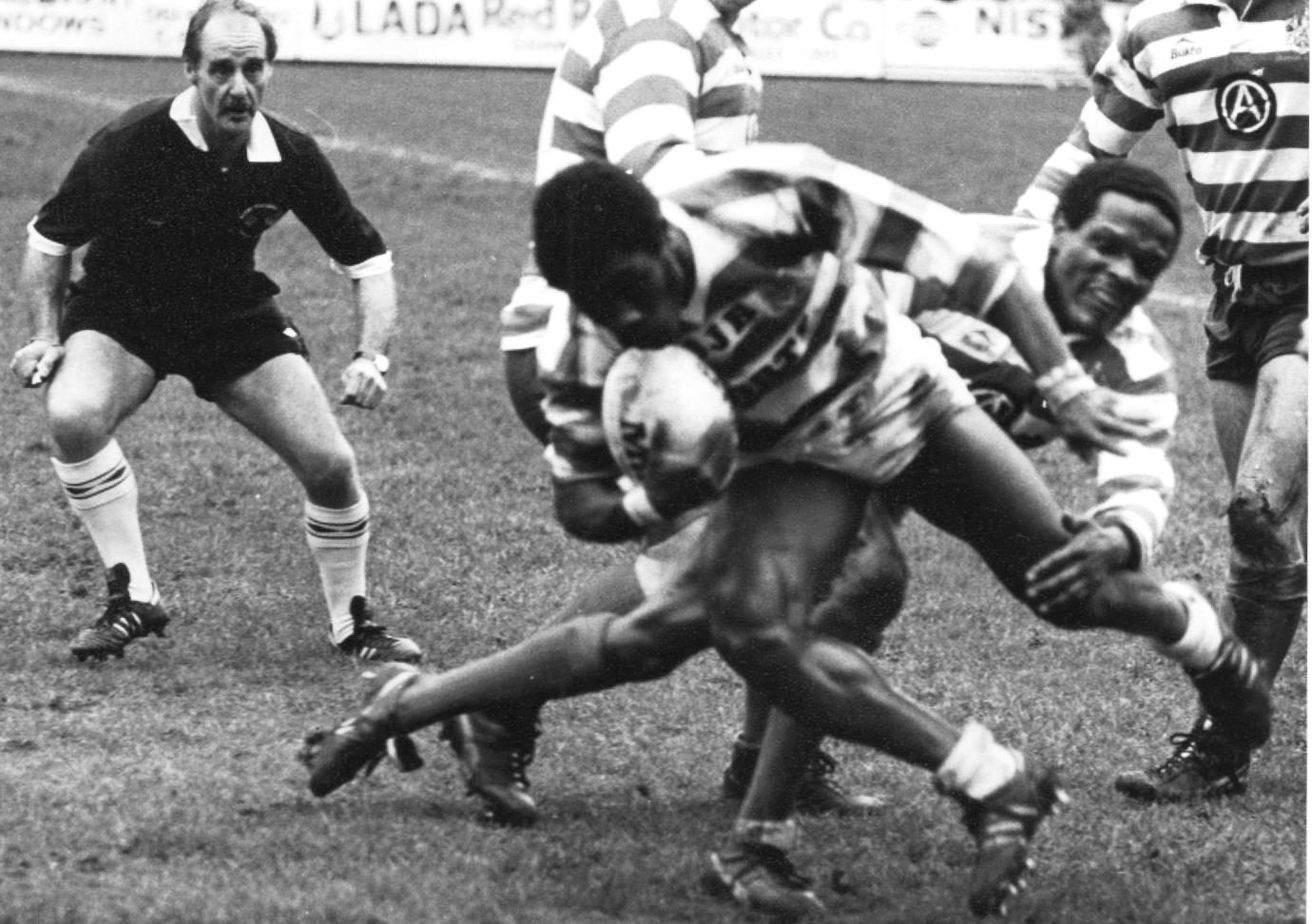 Henderson Gill falls to a tackle from Pat Mitchell - April 8th 1985