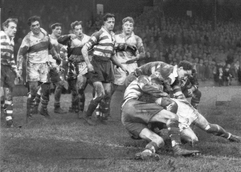 Players from both teams look on as the Oldham defence stop McDowell near the try line at Derwent Park - Dec 13th 1958.