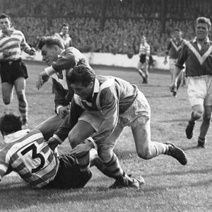 Dennis Ayres is pulled down by Len McIntrye. - Sep 22nd 1956.