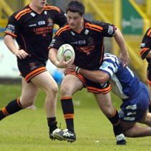 Oldham's Matt Bottom (Ieft) and Paul Ashton (right) move in as Wayne Corcoran looks to make ground towards the Halifax …