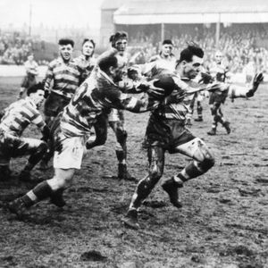 Dick Cracknell evades Welsby and prepares to hand off Collier in the second leg of the cup tie against Liverpool - Feb …