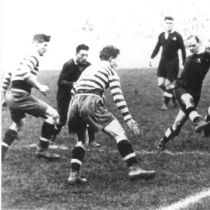 Kiwi half-back Hector Brisbane gets a kick away as the Oldham pack closes in - Oct 23rd 1926.