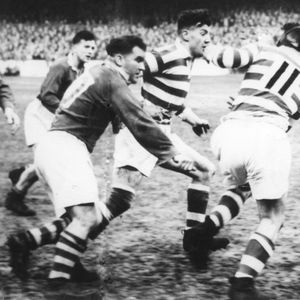Harry Ogden copes with the attentions of the Salford prop, Eynon Hawkins, as he slips the ball to Albert Fearnley who …