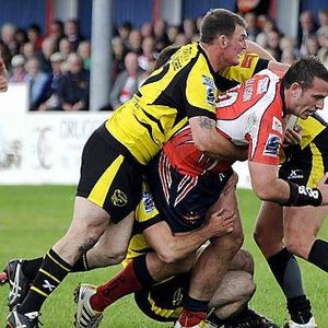 Dave Ellison falls to a three man tackle v South Wales - Aug 1st 2010.