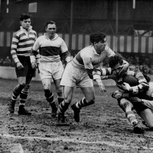 Oldham winger Lionel Emmitt is tackled by Jimmy Honey and Peter Metcalfe of St. Helens, while Alan Davies and George …