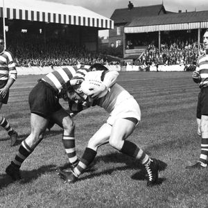 Dick Cracknell (left) and Frank Stirrup look on as a team-mate bring down a Whitehaven player - Aug 30th 1958.